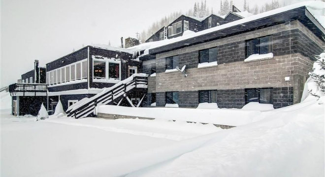 The original lodge buried in fresh snow during a storm