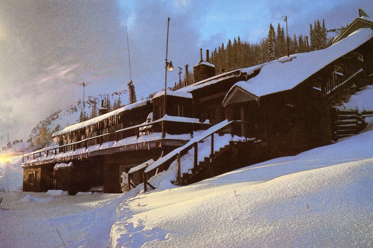 The original Snowpine Lodge at dusk, snow-covered, at the top of Little Cottonwood Canyon