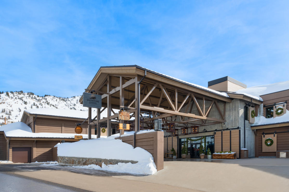 The entrance of the rebuilt Snowpine Lodge under a timber porte-cochere